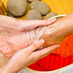 woman foot treatment in paraffin bath at the spa